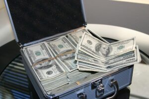 money habits to build wealth — person writing in a finance journal